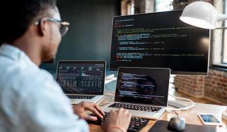 man sitting at computer, programming