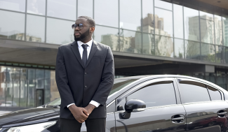 security professional standing on guard at a car.