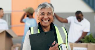 Woman with a clipboard in a safety vest with a volunteer badge