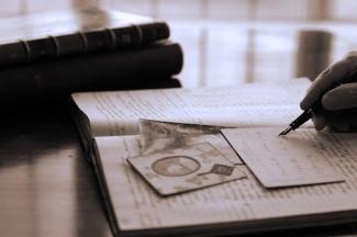 Old books and a person writing on a card